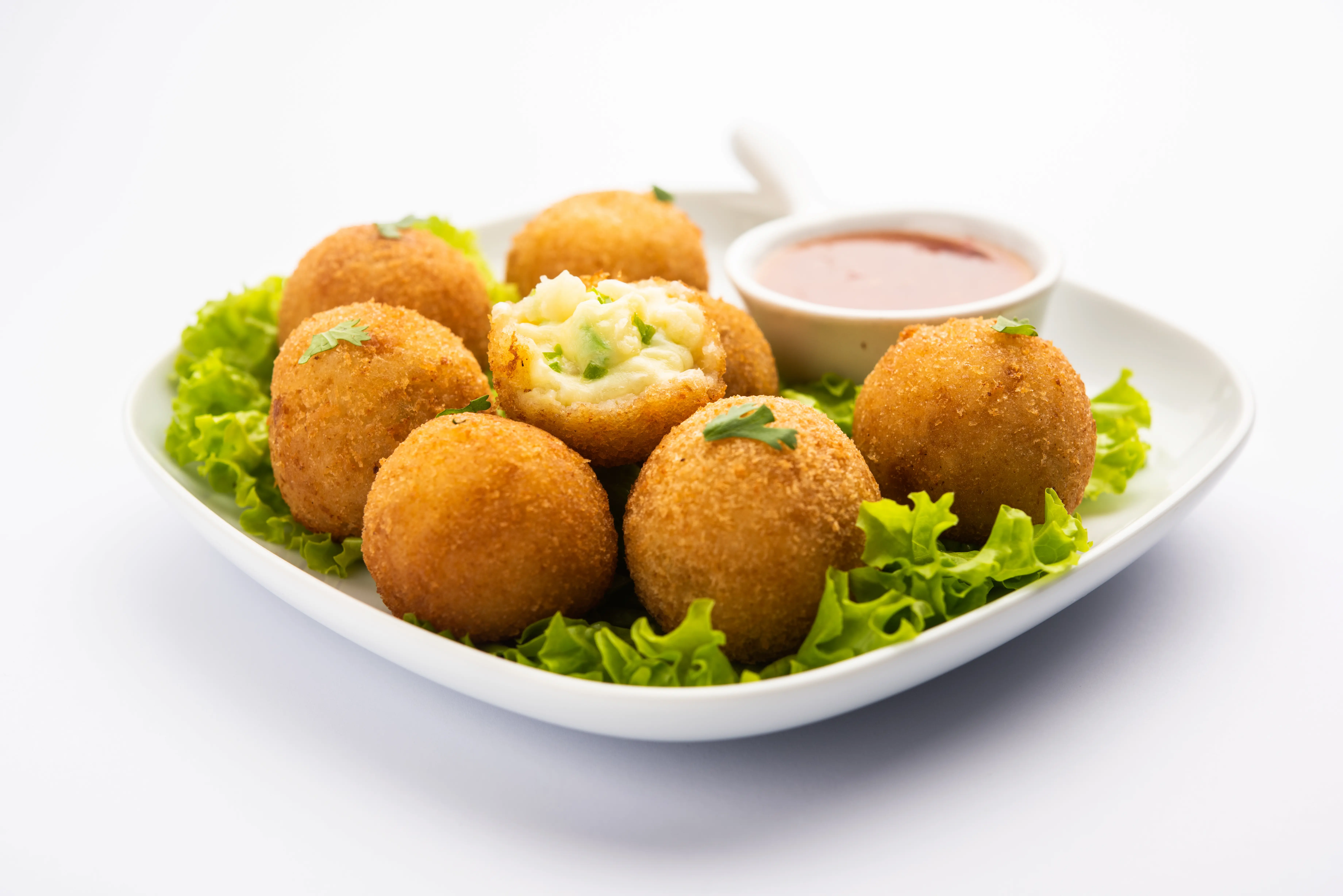 A plate of Jalapeno poppers balls, a sauce on the side.