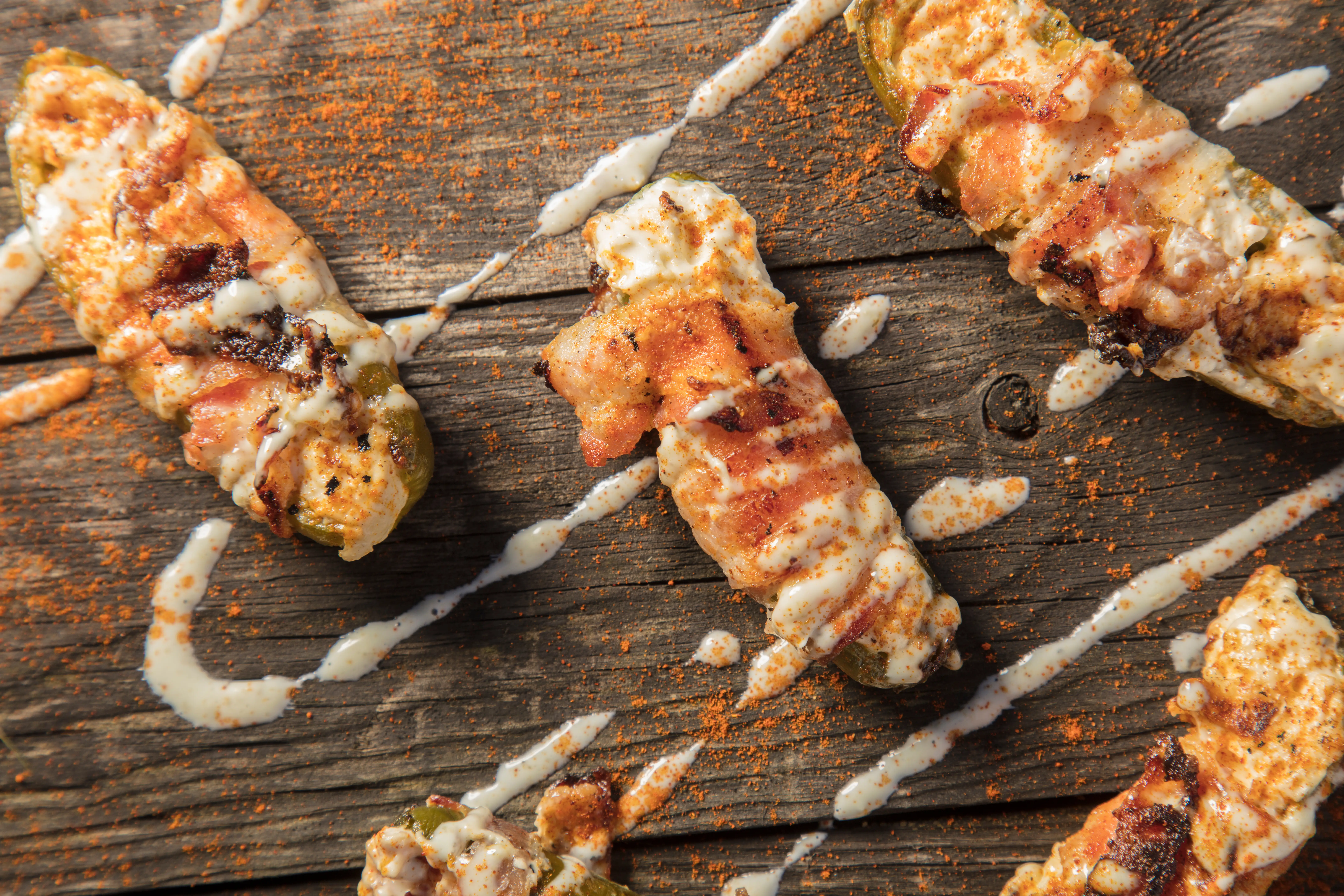 Cream Cheese Filled Bacon Wrapped Jalapeno Poppers On Wood Background