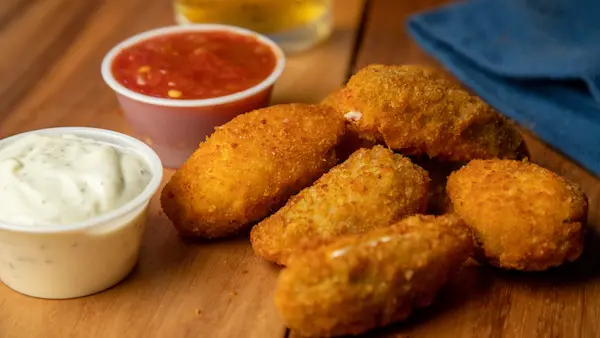 Jalapeno poppers with ranch and ketchup dipping sauce on the sid
