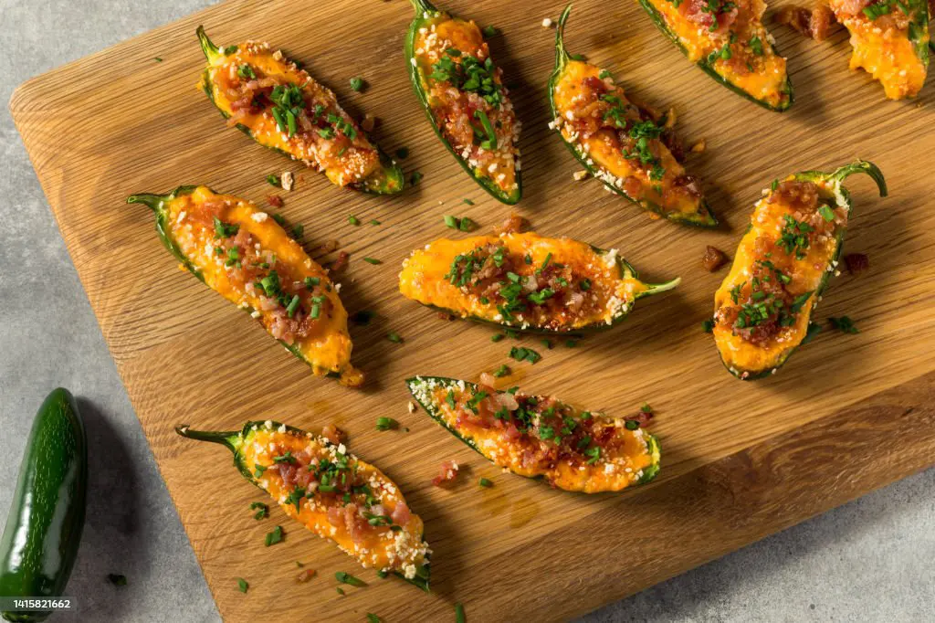 hollowed-out jalapeno with cream cheese with bacon bits and Sesame seed on top.